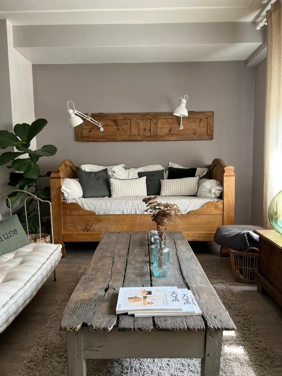 a living room with two beds and a wooden table at Les chambres de Pauline avec spa et climatisation parking moto garage vélo in Albertville