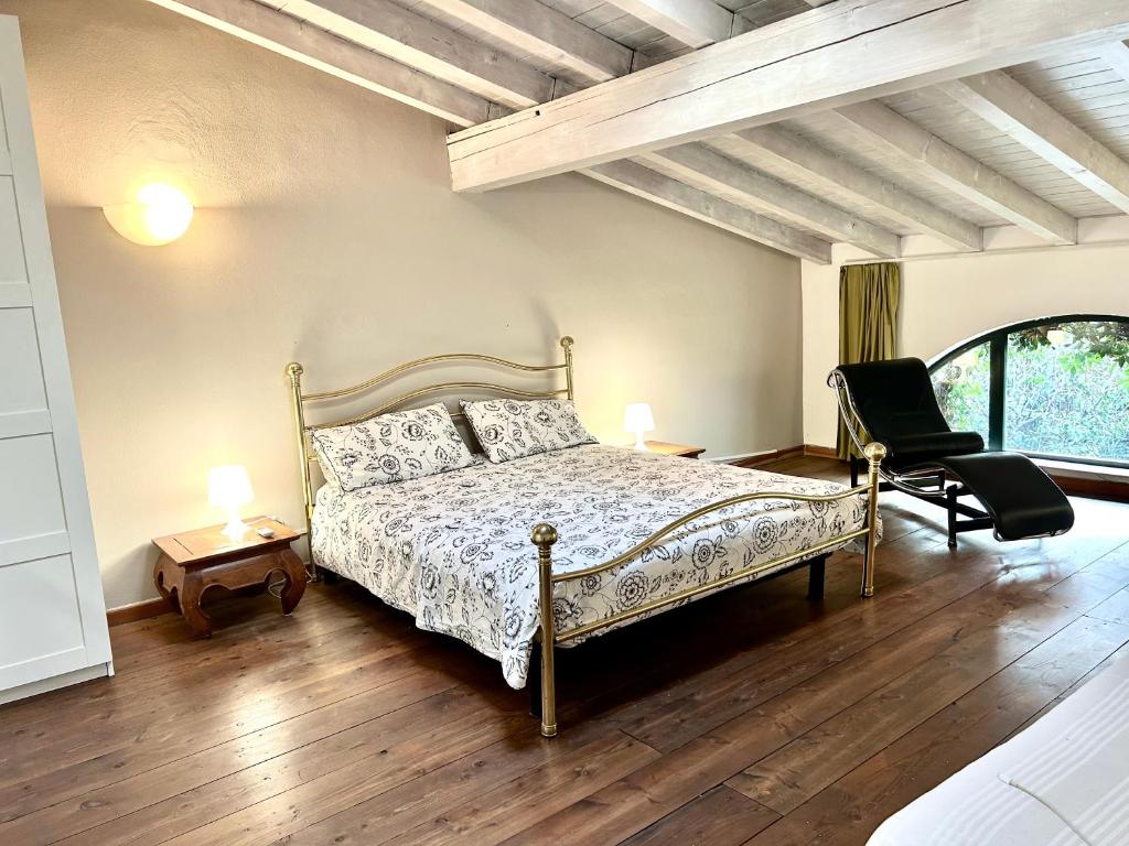 - une chambre avec un lit et une chaise dans l'établissement La Corte di Saronno, à Saronno