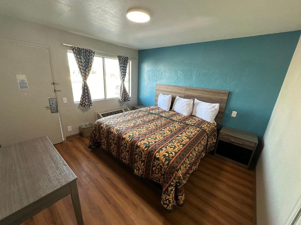 1 dormitorio con cama y pared azul en Super 7 inn, en Joplin