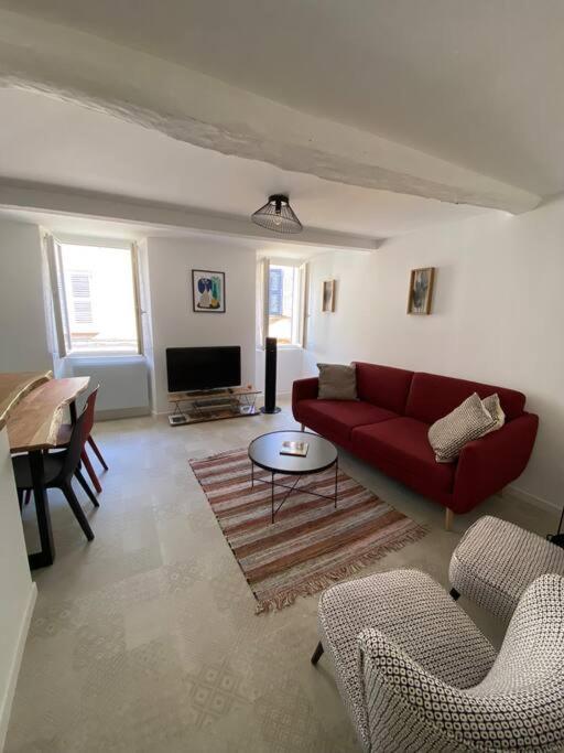 un salon avec un canapé rouge et une table dans l'établissement Appartement Cosy à Collobrières, à Collobrières