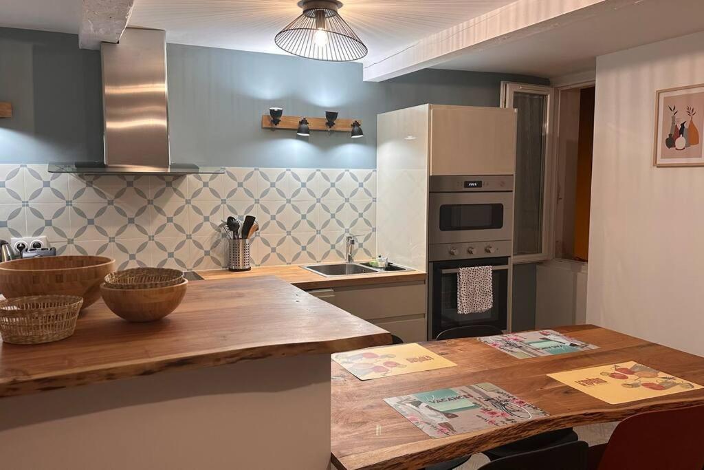 a kitchen with a wooden table and a counter top at Appartement Cosy à Collobrières in Collobrières