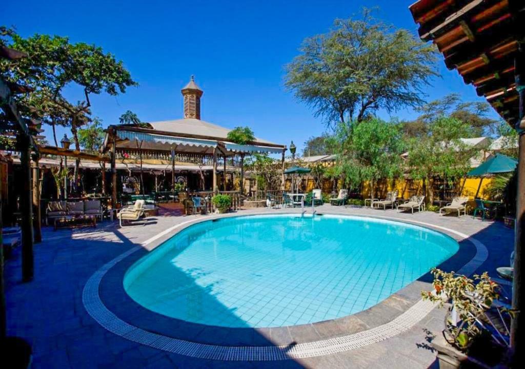 a swimming pool at a resort with a pavilion at Hotel & Hacienda El Carmelo in Ica