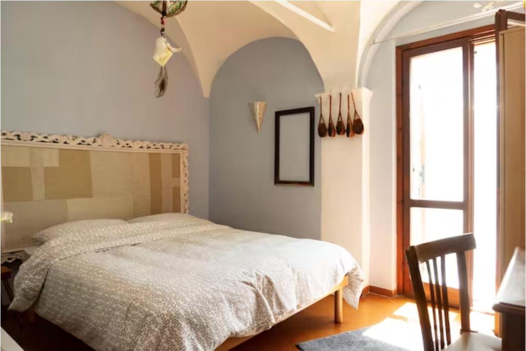 a bedroom with a bed and a large window at la casa degli Archi in Pesaro