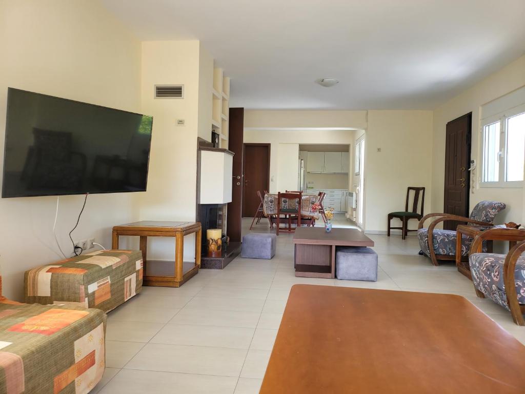 a living room with a large flat screen tv on the wall at Green House Marathon - Greece in Nea Makri