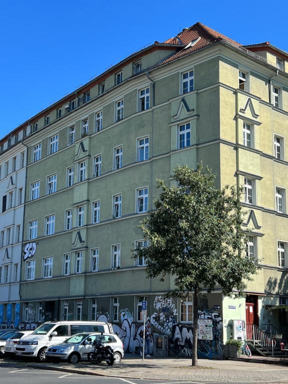 un grand bâtiment avec des voitures garées devant lui dans l'établissement Sweet Home Inside Dresden Rooms, à Dresde