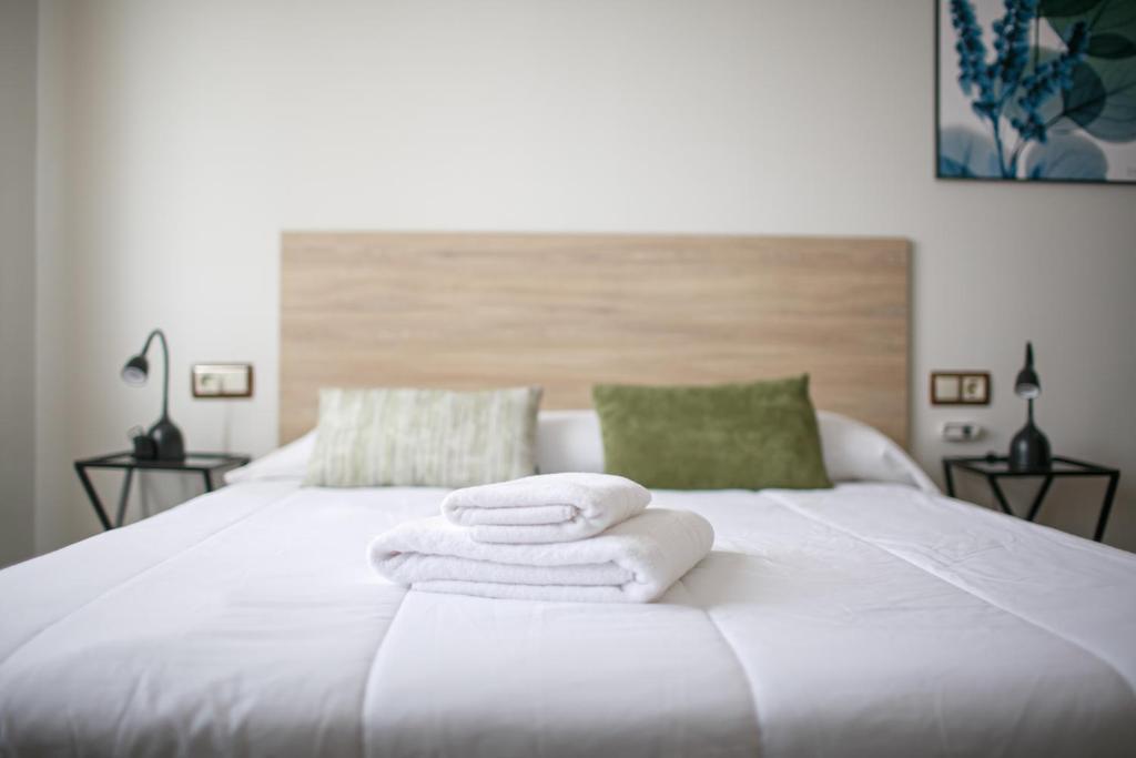 three towels sitting on top of a white bed at El Maestrazgo in Xert