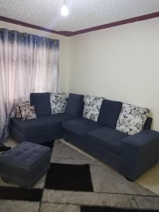 a living room with a blue couch in a room at Ole kerai #101 in Nairobi