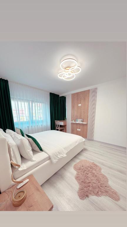 a bedroom with a large white bed and a couch at Scandinavia Apartment 1 in Piatra Neamţ