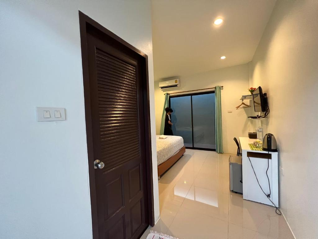 uma sala com uma porta que leva a um quarto em Cmon guesthouse em Phetchaburi