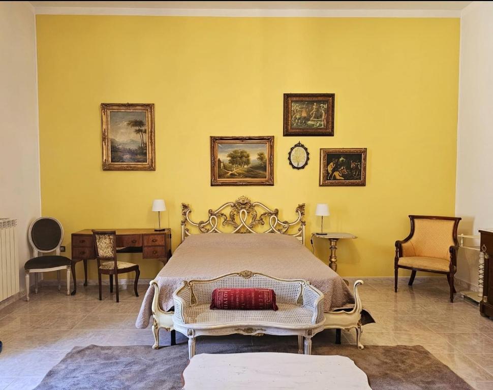 um quarto com uma cama numa parede amarela em CAROLINA'S APARTMENT em Caserta