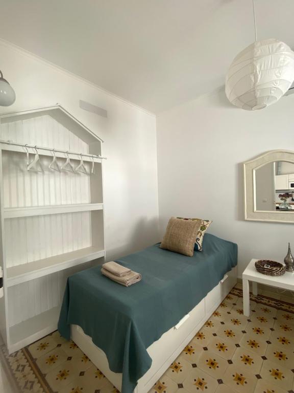 a bedroom with a bed with blue sheets and a mirror at Casa Monte Tamissa in Vila Real de Santo António