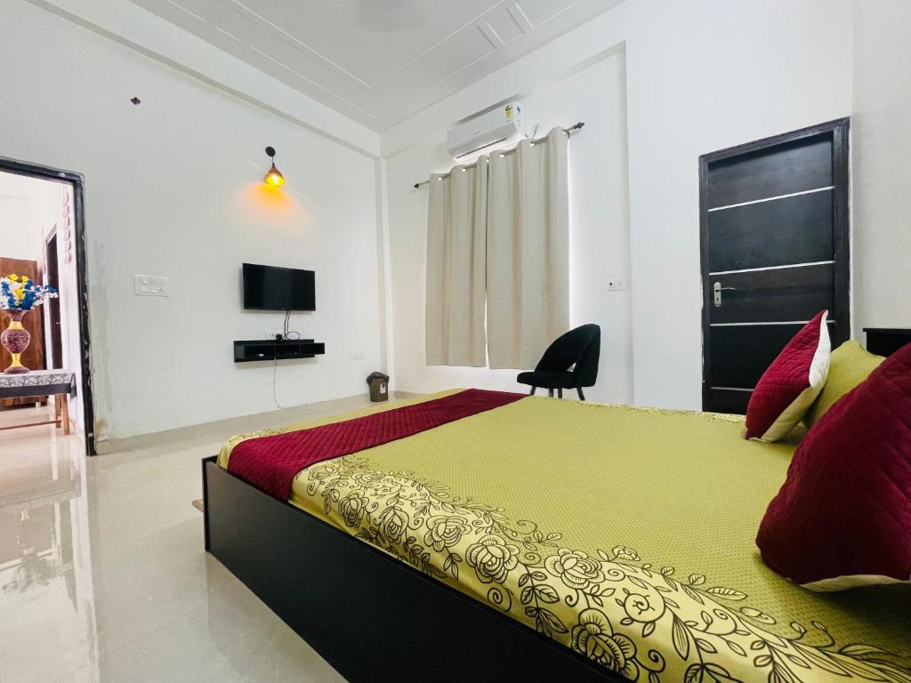 1 dormitorio con 1 cama grande y TV en Atulyam Stays Sushant Golf City en Lucknow