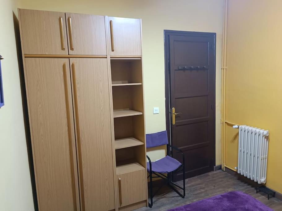 a closet with a door and a chair in a room at León Antiguo Palomera in León