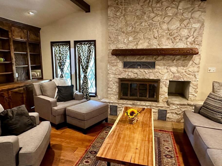 a living room with a stone fireplace and a coffee table at Beautiful Farm Home near NMSU in Las Cruces