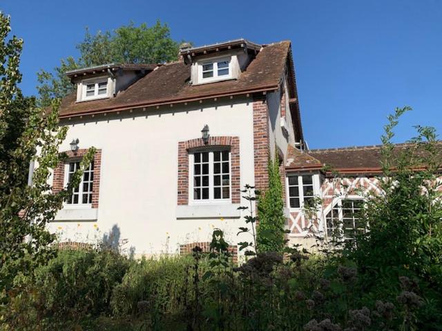 una grande casa bianca con tetto marrone di GÎTE VIGNERAIE a Sainte-Gemme-Moronval
