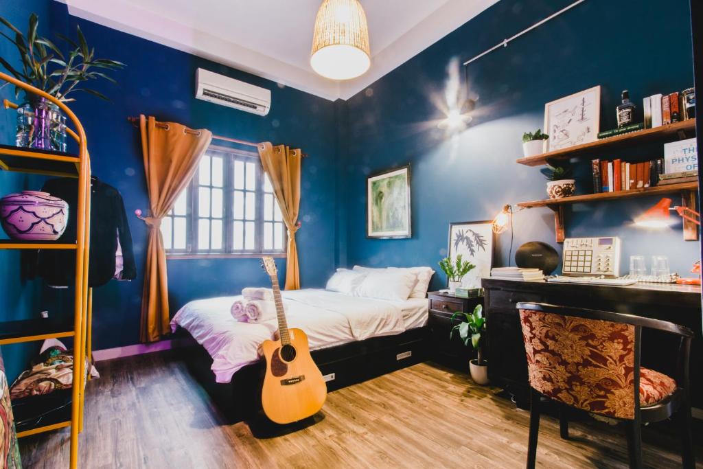 a bedroom with a bed with a guitar in it at The Time Machine in Ho Chi Minh City