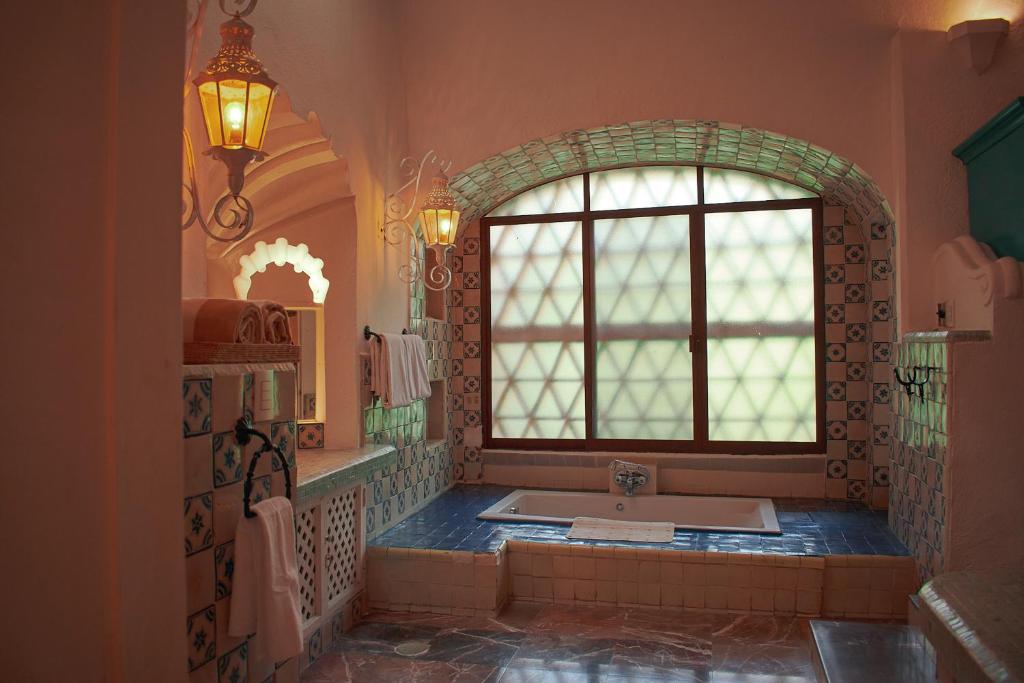 bagno con vasca, finestra e lavandino di Casa Lisa ad Acapulco