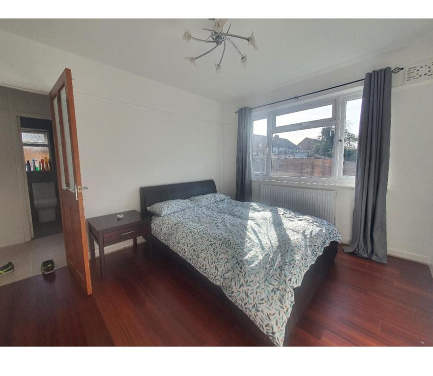 a bedroom with a bed and a window at Ritzs place in Northolt