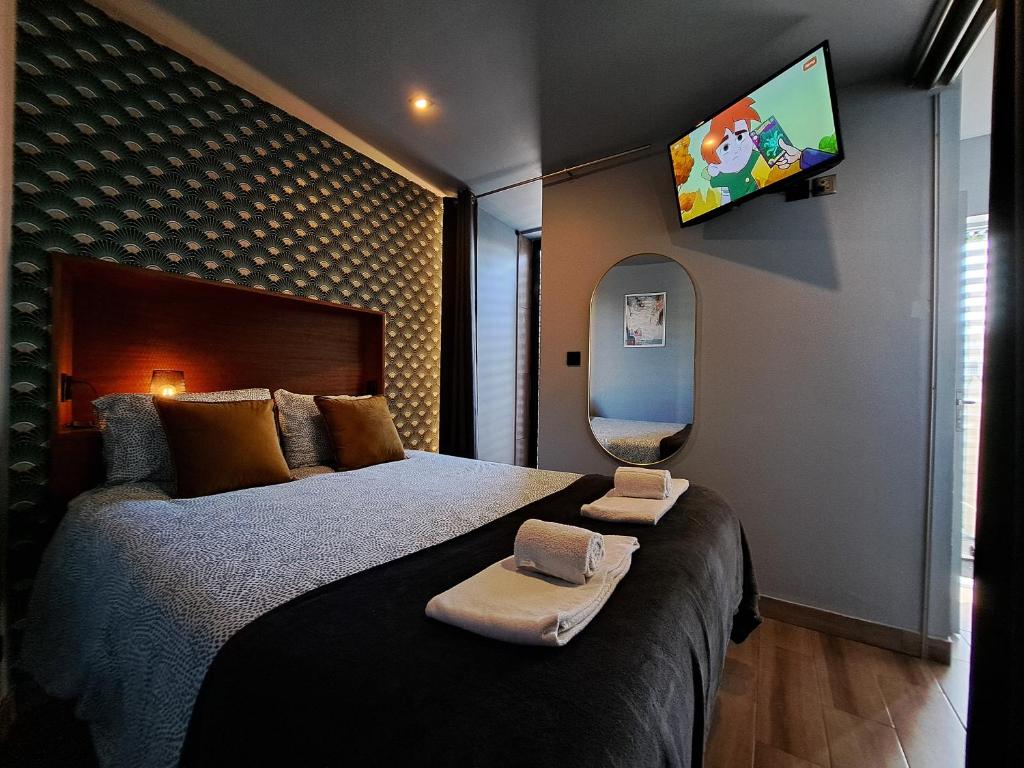 a bedroom with a large bed with a tv on the wall at Kiosk 550 Apartment - Póvoa de Varzim in Póvoa de Varzim