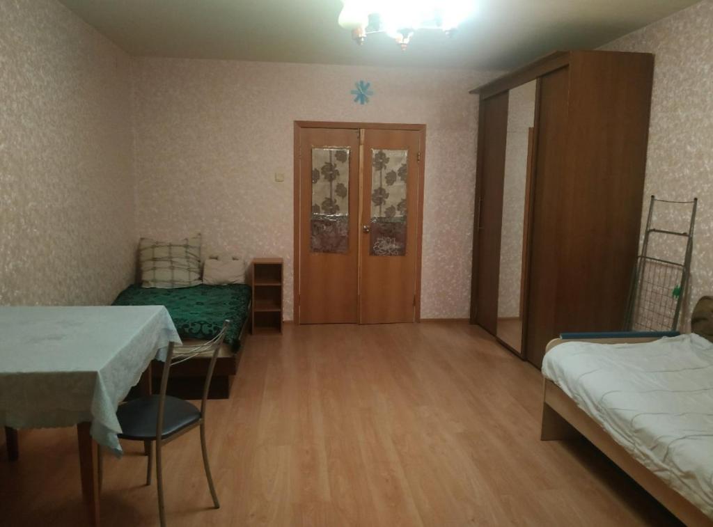 Pokój z 2 łóżkami, stołem i krzesłami w obiekcie Battenbot Apartment 9p8 