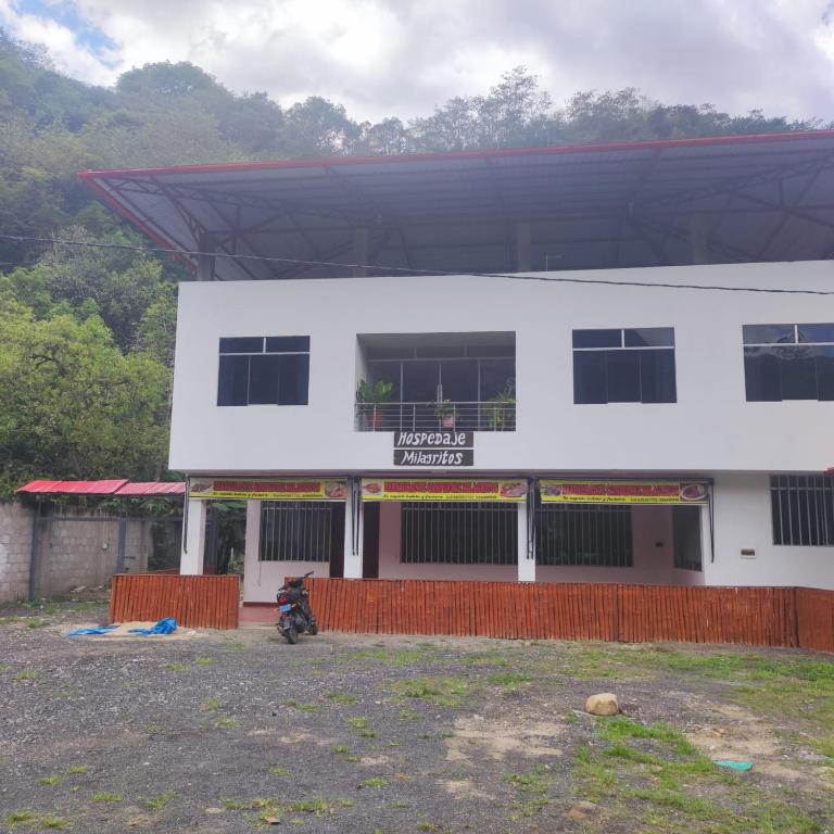 un bâtiment blanc avec une moto garée devant lui dans l'établissement HOSPEDAJE MILAGRITOS, à Chachapoyas