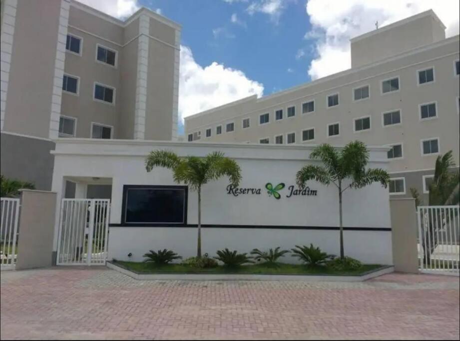 un grand bâtiment avec des palmiers devant lui dans l'établissement Apartamento próximo ao aeroporto, à Fortaleza