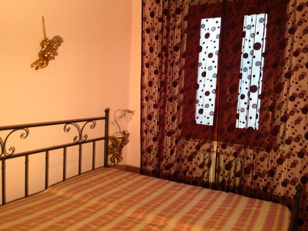 a bedroom with a bed and a window with a curtain at Stanza Bellaria in Pontedera