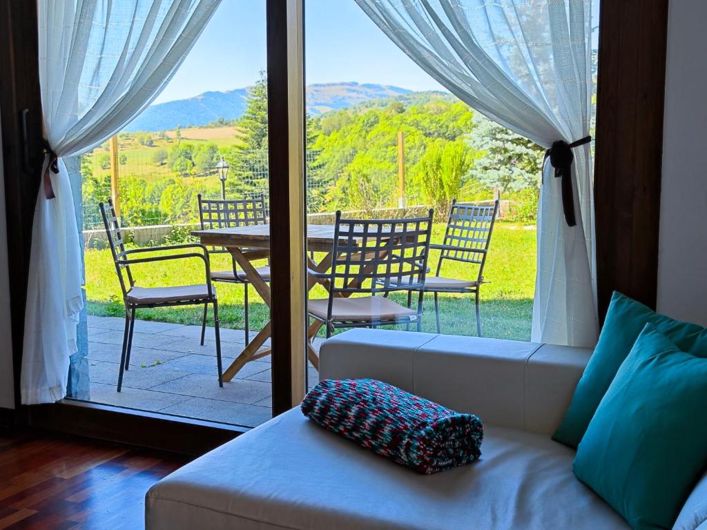 a living room with a couch and a table and chairs at L'Oasi de Molló in Molló