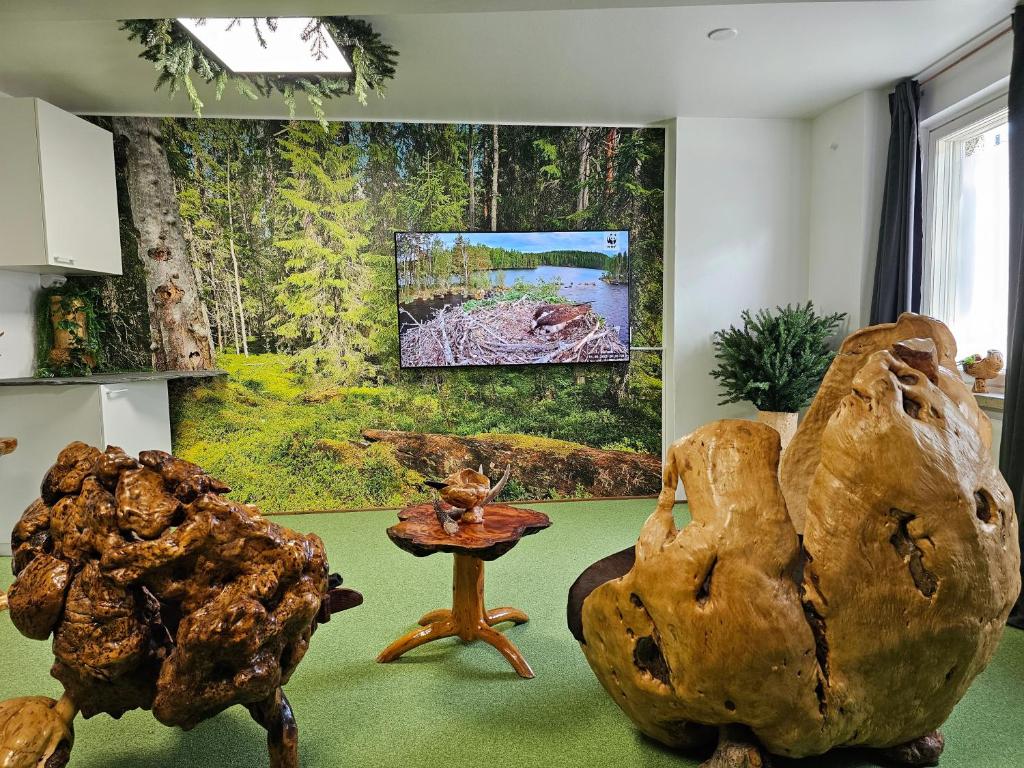 a living room with a table and two large logs at ROVIO REST IN FOREST in Jyväskylä