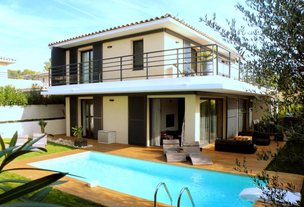 a villa with a swimming pool in front of a house at Le Hameau de la Crique de l'Anglaise in Bandol