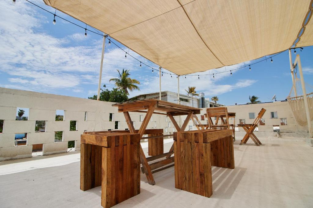 a picnic table and two chairs under a large umbrella at Hotel Casa Ceci Inn in San José del Cabo