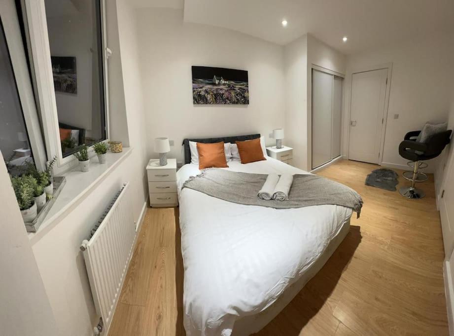 1 dormitorio con cama blanca y ventana en Comfortable 2 BR Flat TH542 en Basildon