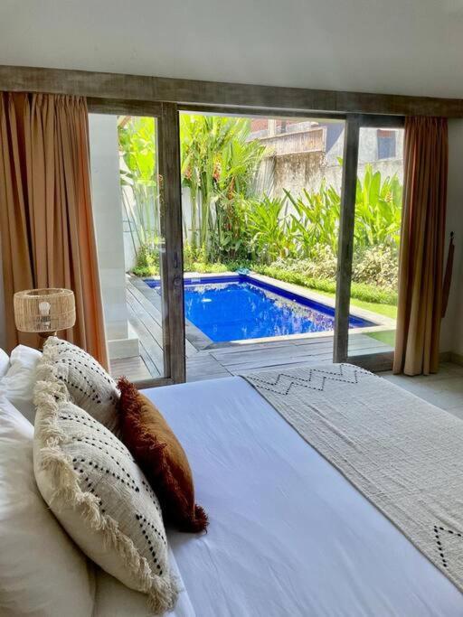 um quarto com uma cama e vista para uma piscina em Villa Salamanca em Dalung