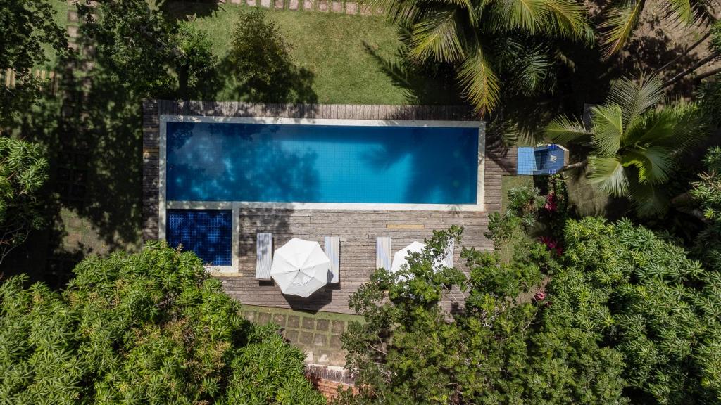 an overhead view of a swimming pool with a white umbrella at Brisa da Bahia in Trancoso