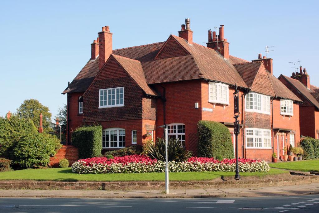 a brick house with flowers in front of a street at Charming 1800s Port Sunlight Worker's Cottage in Port Sunlight