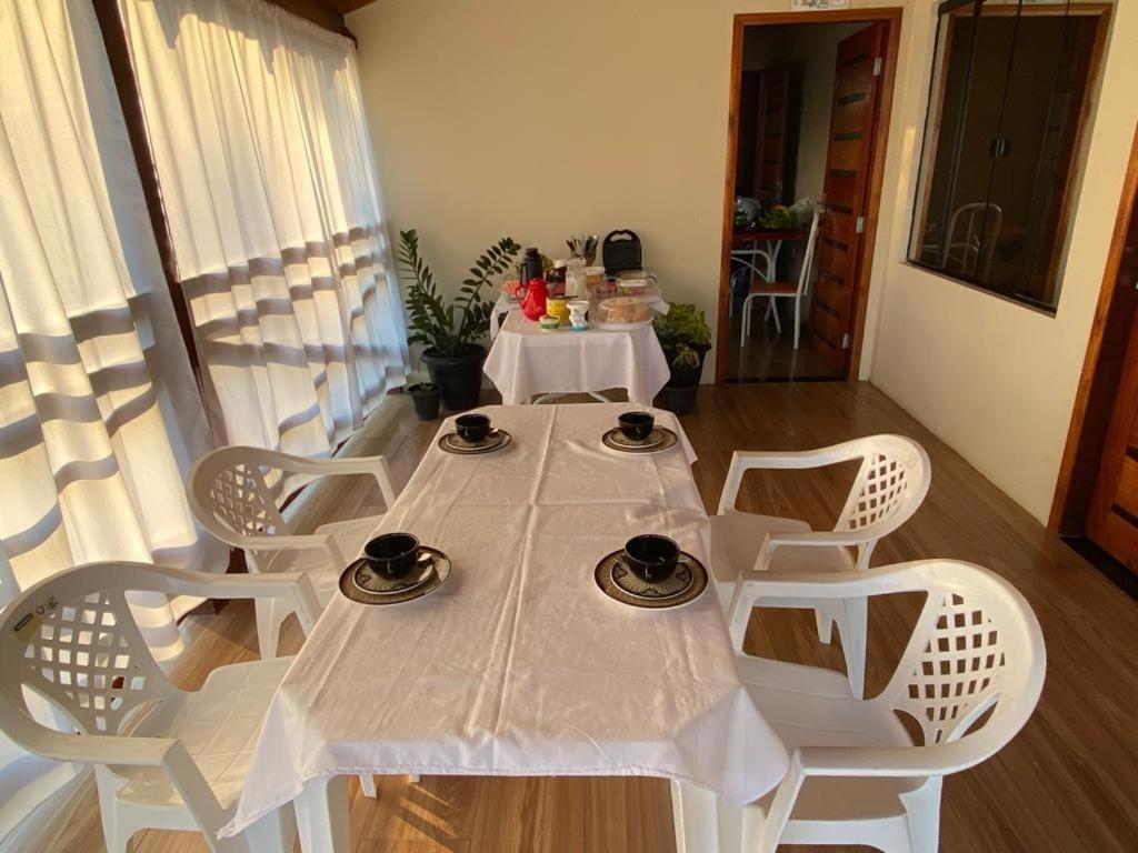 einen weißen Tisch und Stühle in einem Zimmer in der Unterkunft Pousada Mãe Dita 
