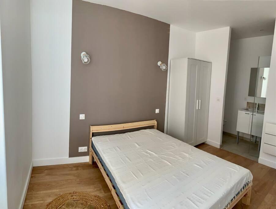 una camera con un letto nell'angolo di una stanza di Maison centre ville confortable a Marmande