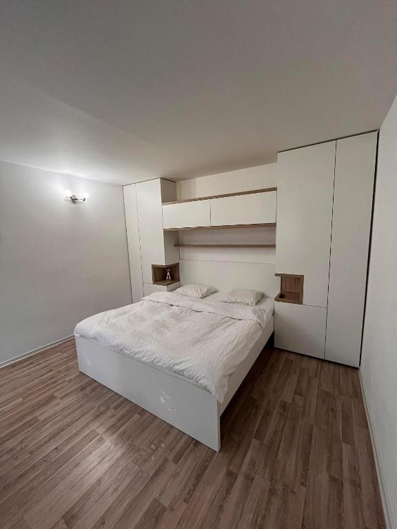 a bedroom with a white bed and white cabinets at Luxury apartman L&A in Košice