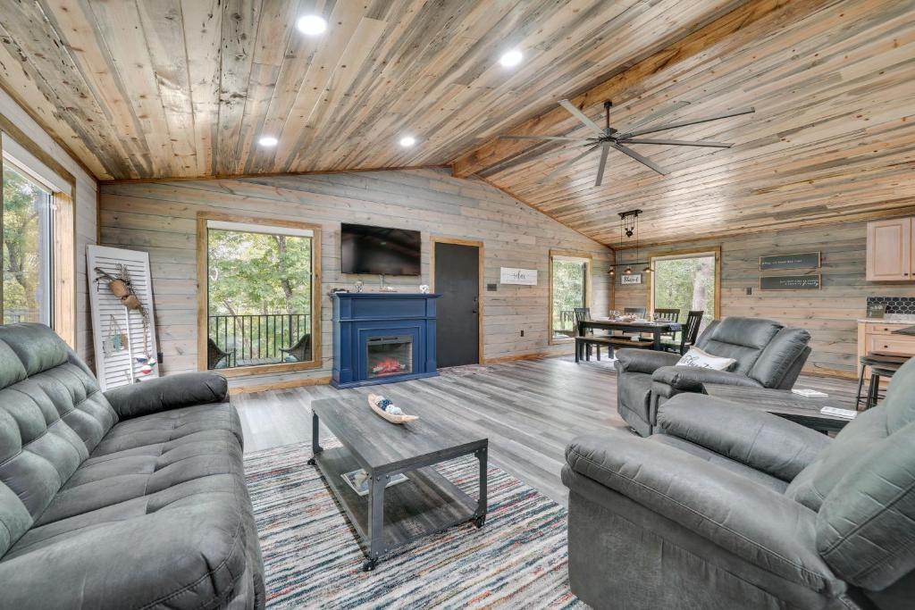 a living room with a couch and a fireplace at Broken Bow Riverfront Cabin with Private Hot Tub! in Broken Bow