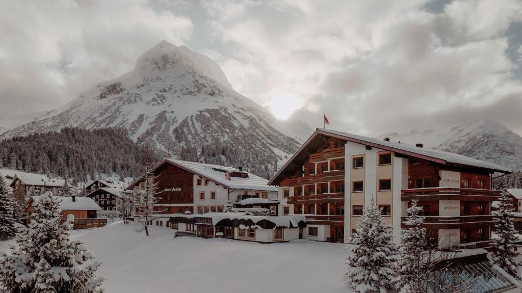 a ski lodge with a mountain in the background at Hotel Austria in Lech am Arlberg