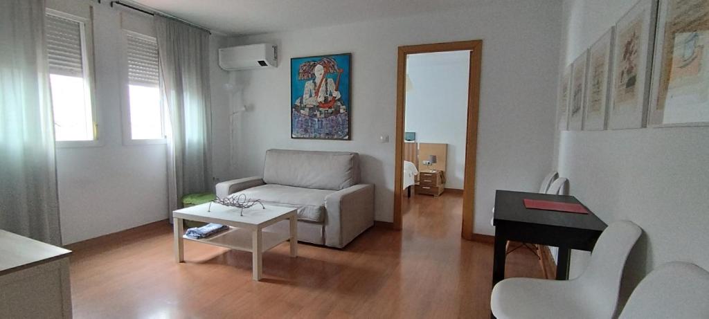 ein Wohnzimmer mit einem Sofa und einem Tisch in der Unterkunft Apartamento Torres19 in Sevilla