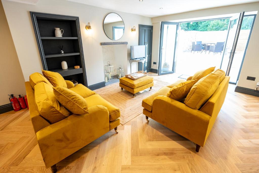 una sala de estar con 2 sofás amarillos y un espejo en Siabod - Snowdonia, North Wales, en Bethesda