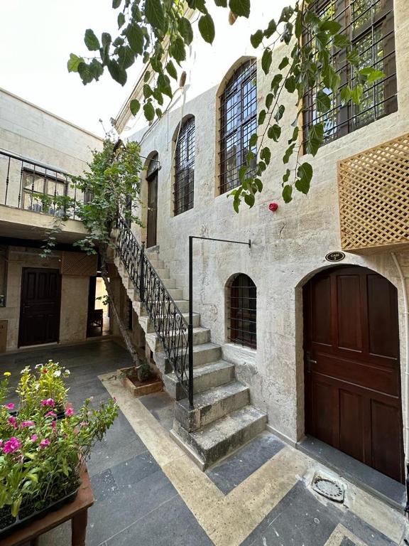a building with a staircase and a door and flowers at Hayadlı Konak Butik Otel in Gaziantep