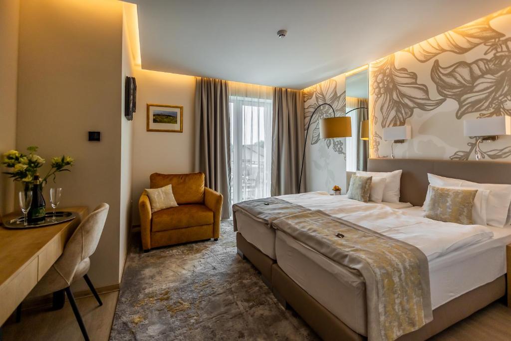 una habitación de hotel con una cama grande y una silla en Mokka House Panzió, en Miskolc