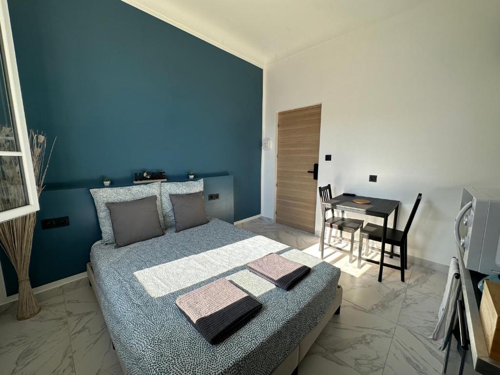 a blue bedroom with a bed and a table at La maison de Giulia Menton in Menton