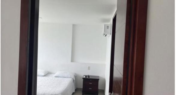 1 dormitorio con cama y espejo en hotel amazonico, en Mocoa
