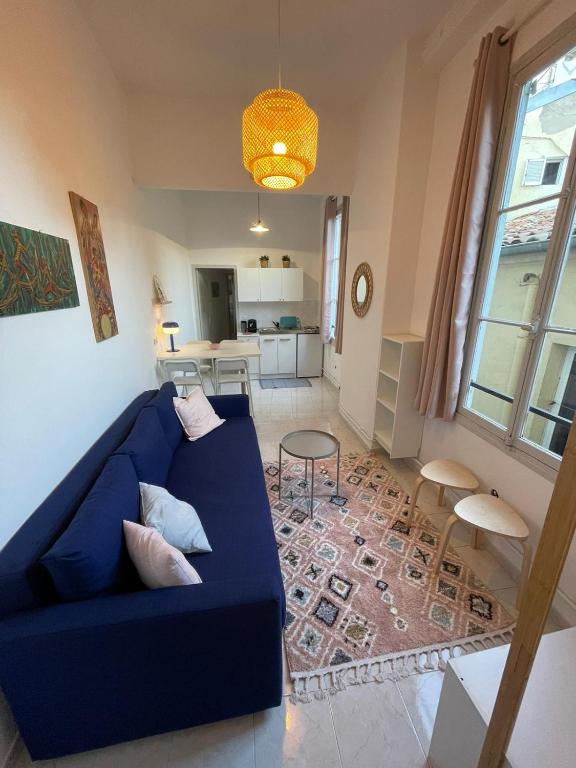 un salon avec un canapé bleu et une table dans l'établissement Patio de la pietonne, à Menton