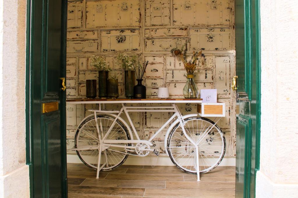 Casa dos Cucos في إيريسييرا: دراجة بيضاء متوقفة أمام الجدار
