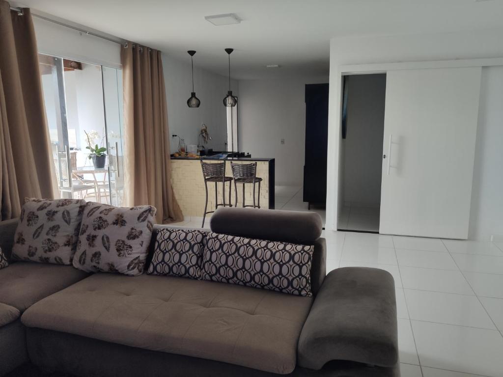 a living room with a couch and a kitchen at Casa Lenger in Aracaju