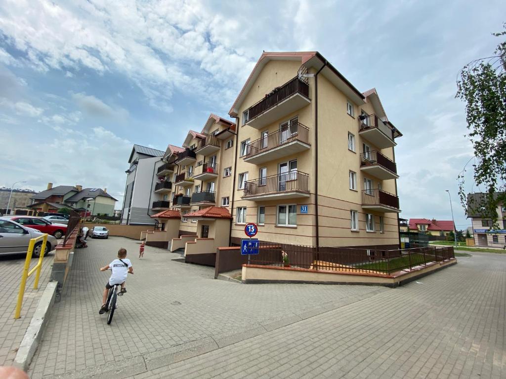 a child riding a bike in front of a building at Bydgoska 31 in Suwałki